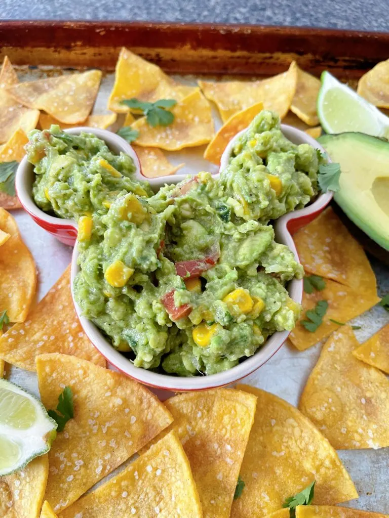 A bowl of guacamole and tortilla chips.
