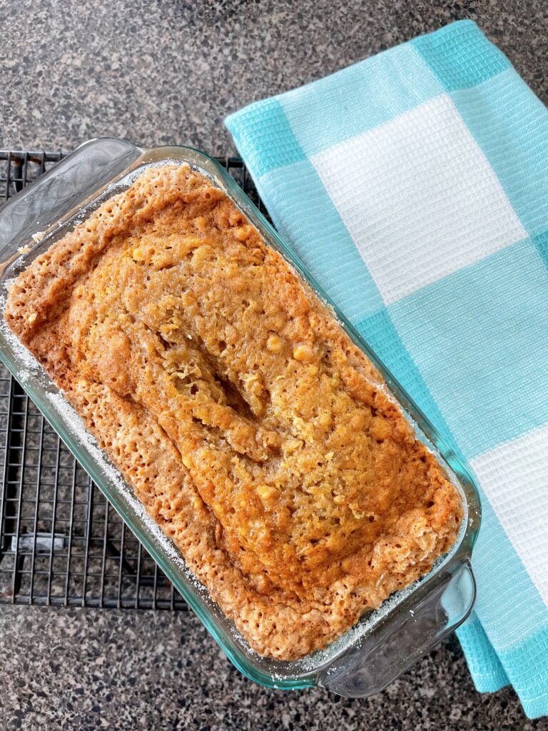 A loaf of zucchini bread and a blue and white towel.