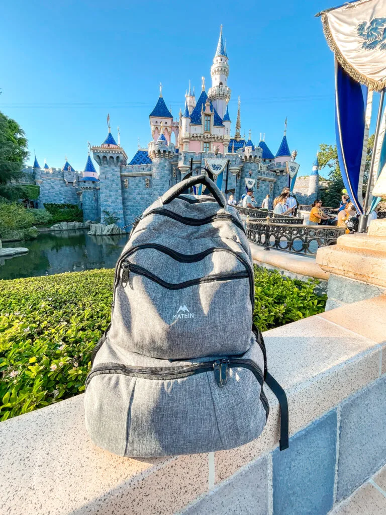 A backpack in front of Cinderella Castle at Disneyland.