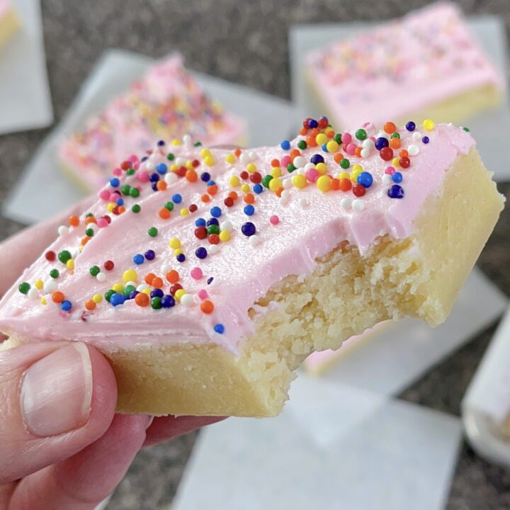 A cream cheese sugar cookie bar with a bite taken out.