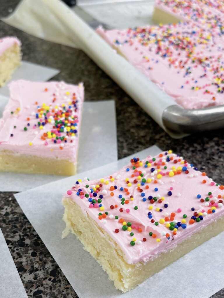 Cream cheese sugar cookie bars with frosting and sprinkles.