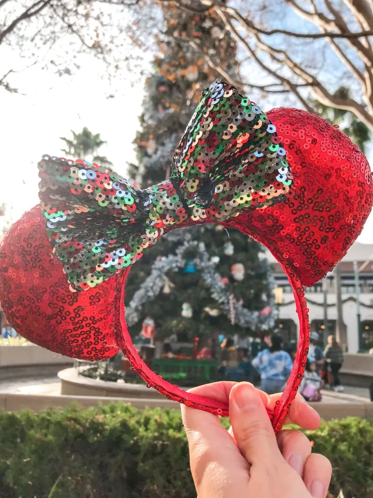 Minnie ears in front of the Christmas tree on Buena Vista Street at Disney California Adventure.