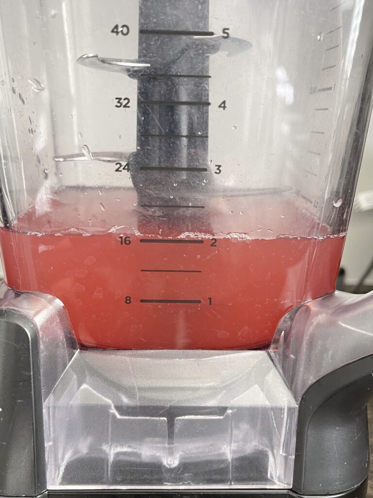 Two cups of watermelon juice in a blender.