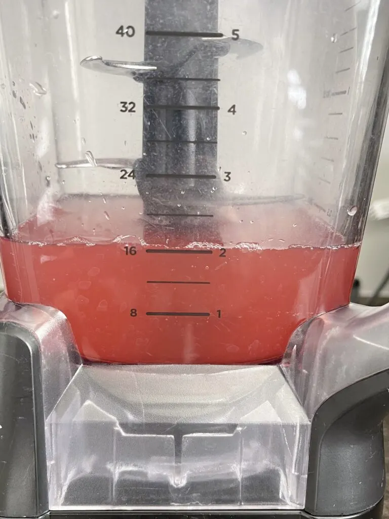Two cups of watermelon juice in a blender.