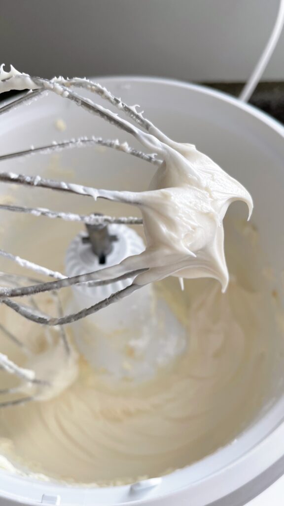 Cream cheese frosting on a whisk.