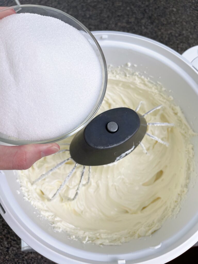 A bowl of sugar about to be mixed into cheesecake batter.