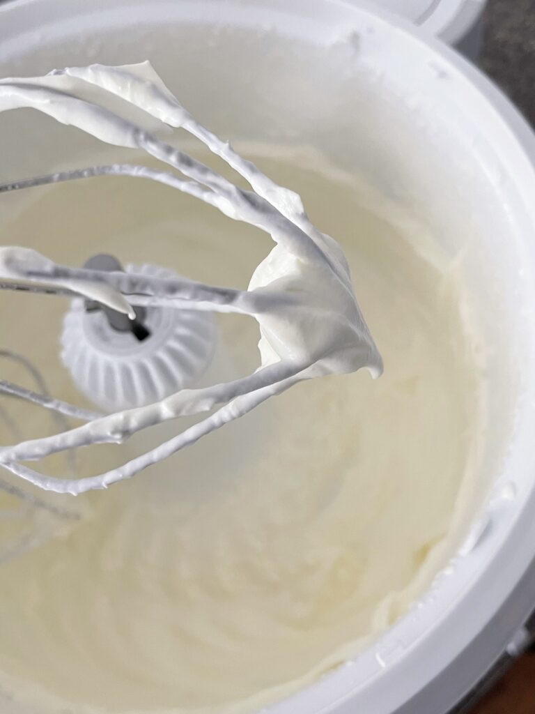 White chocolate whipped cream on a whisk.