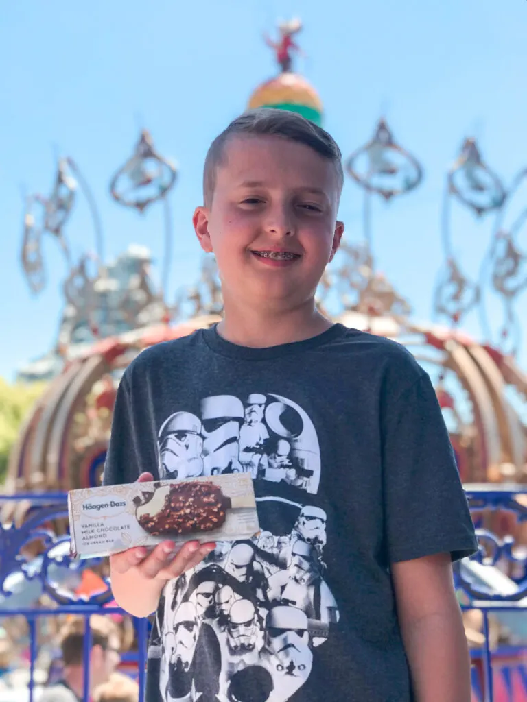 A boy with an ice cream bar at Disneyland.