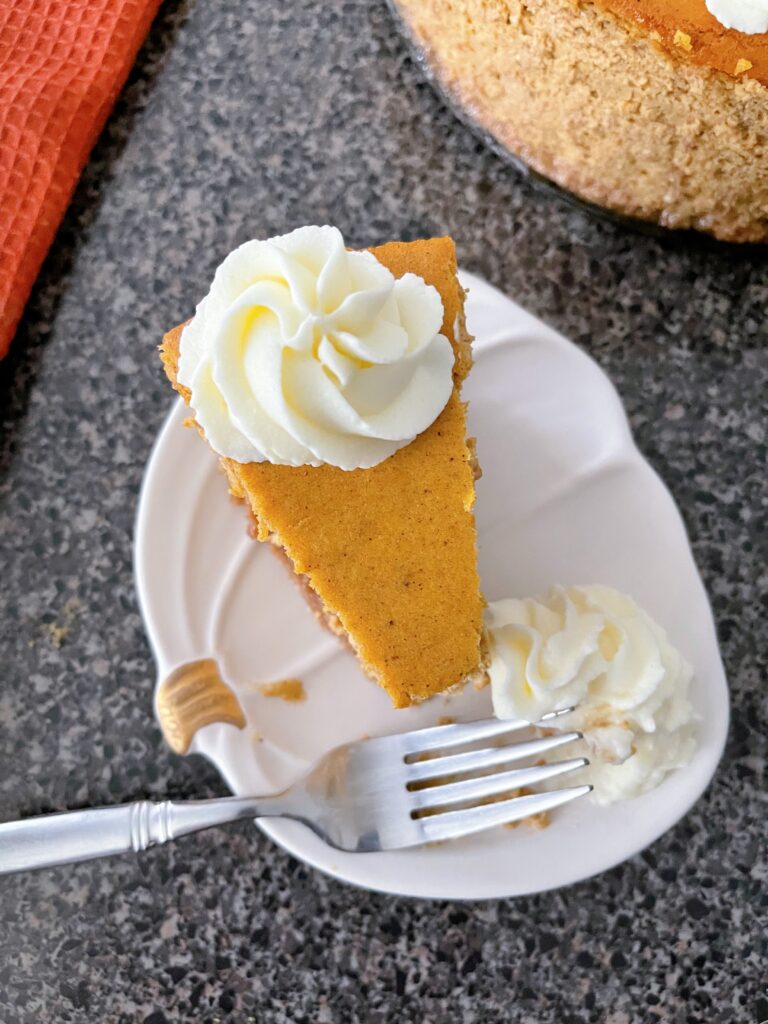 A slice of copycat Cheesecake Factory pumpkin cheesecake with a fork.