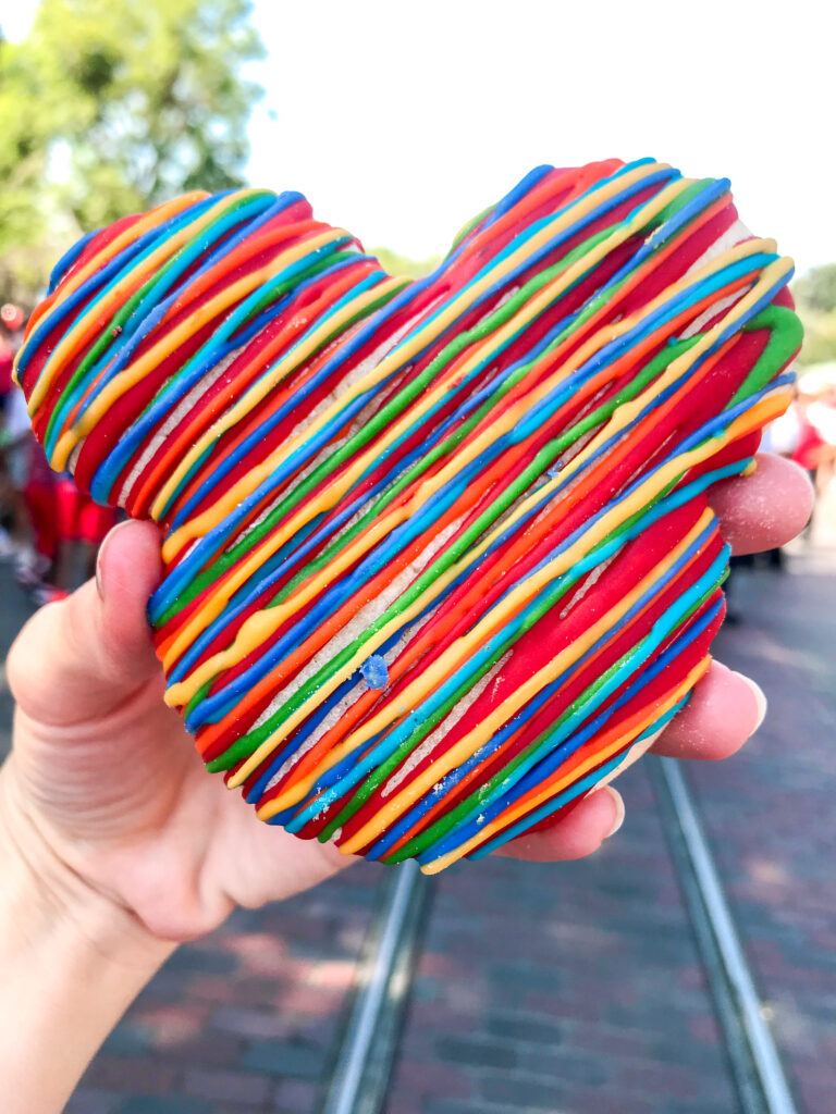 A Mickey Mouse-shaped sugar cookie drizzled with colored candy melts.