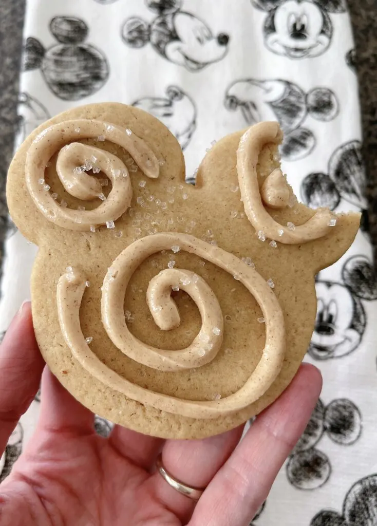 A Mickey Mouse Churro Sugar Cookie with a bite out of the ear.