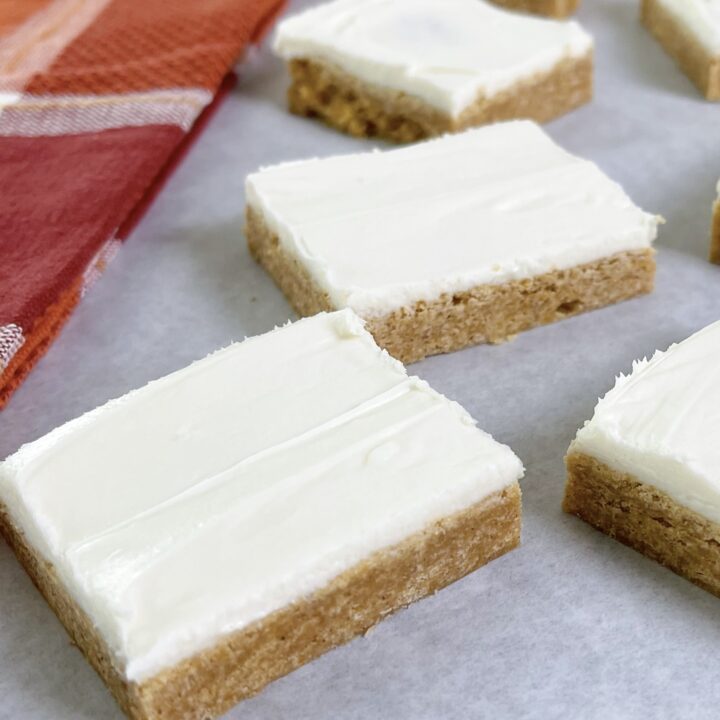 A picture of pumpkin sugar cookie bars with cream cheese frosting.