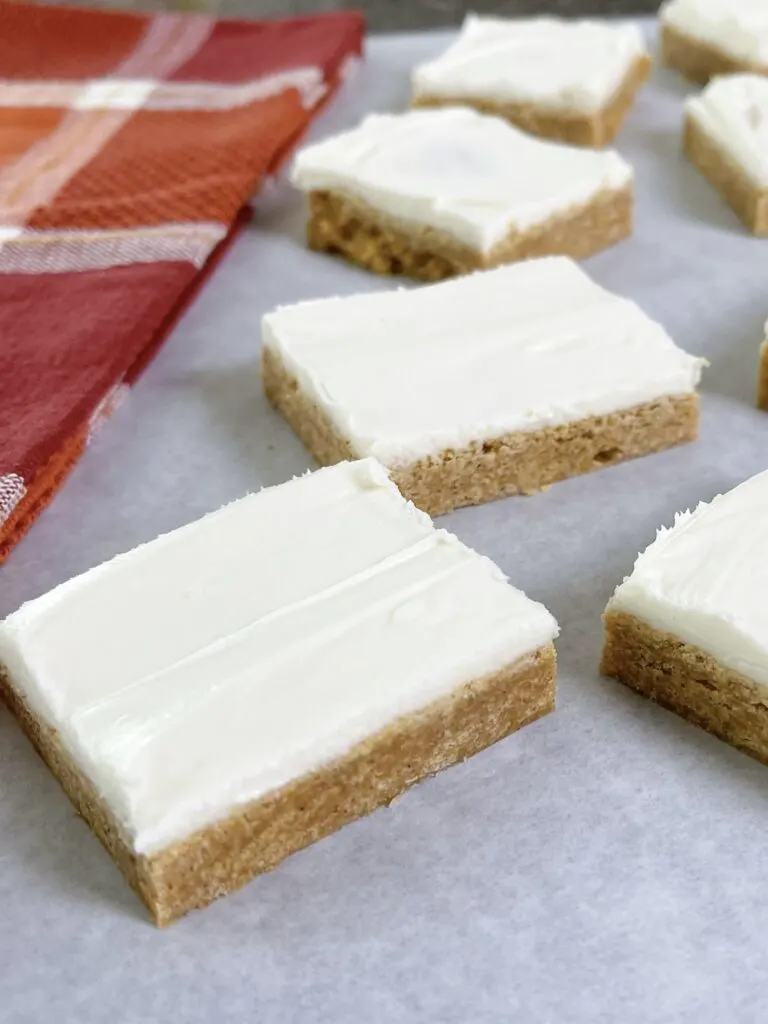 A picture of pumpkin sugar cookie bars with cream cheese frosting.