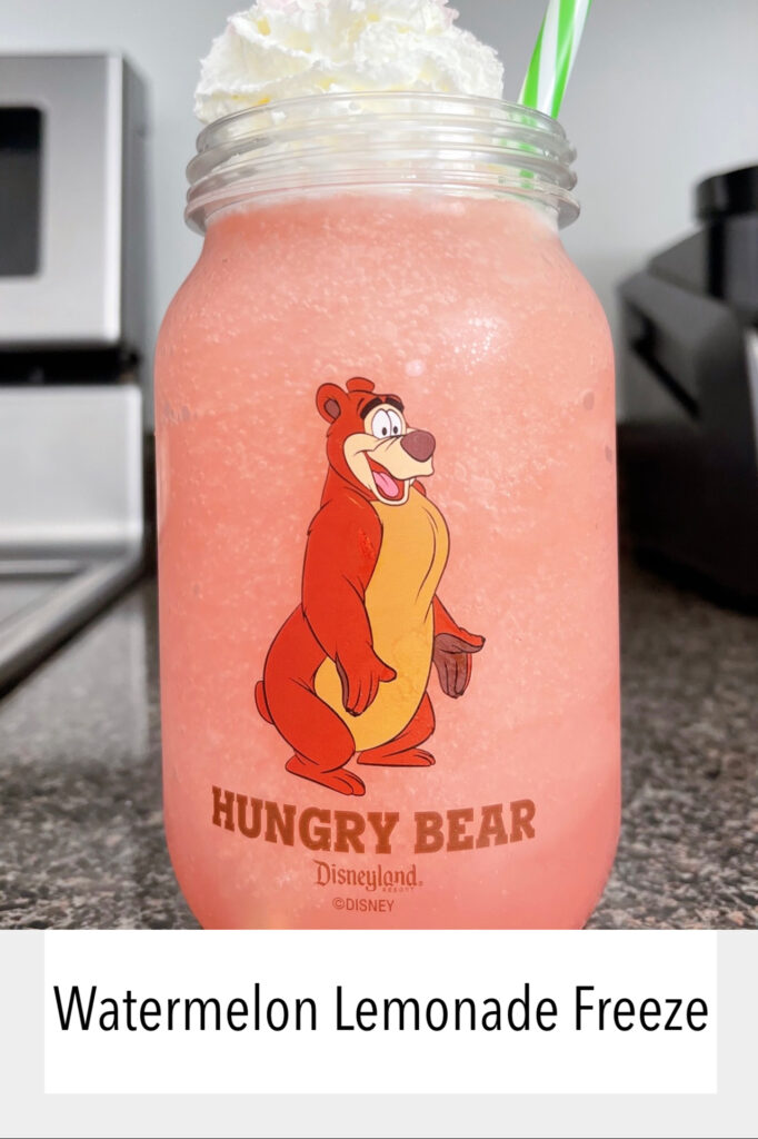 A Disneyland Hungry Bear Restaurant mason jar cup filled with watermelon lemonade freeze.