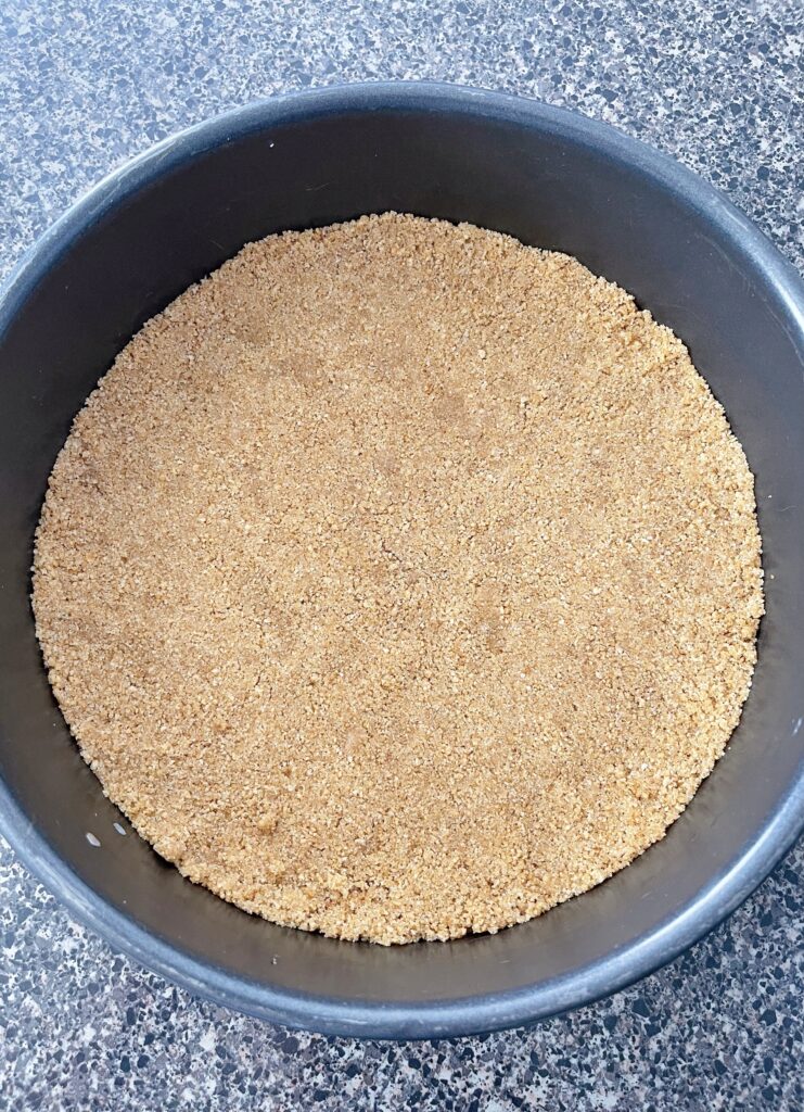 Graham cracker crust in a springform pan.