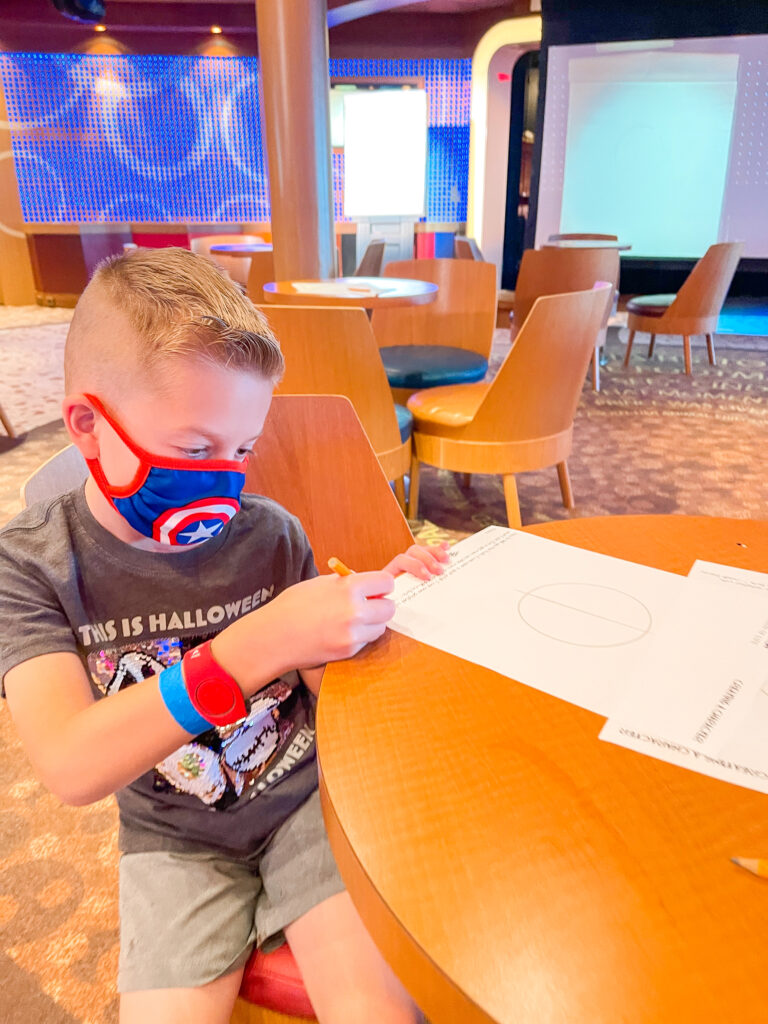 A child drawing a Disney character on a Disney Cruise.