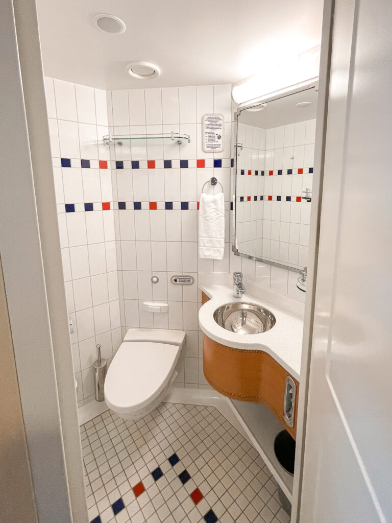 First bathroom with a toilet in Disney Dream stateroom 8614.