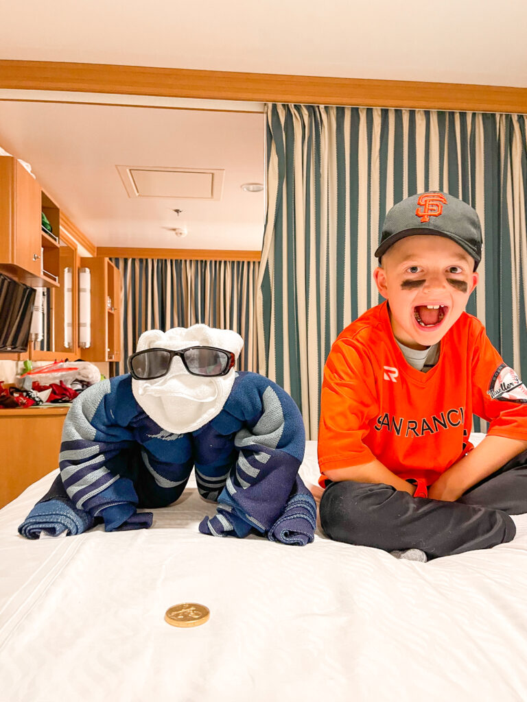 A boy and a towel animal in stateroom 8614 on the Disney Dream.