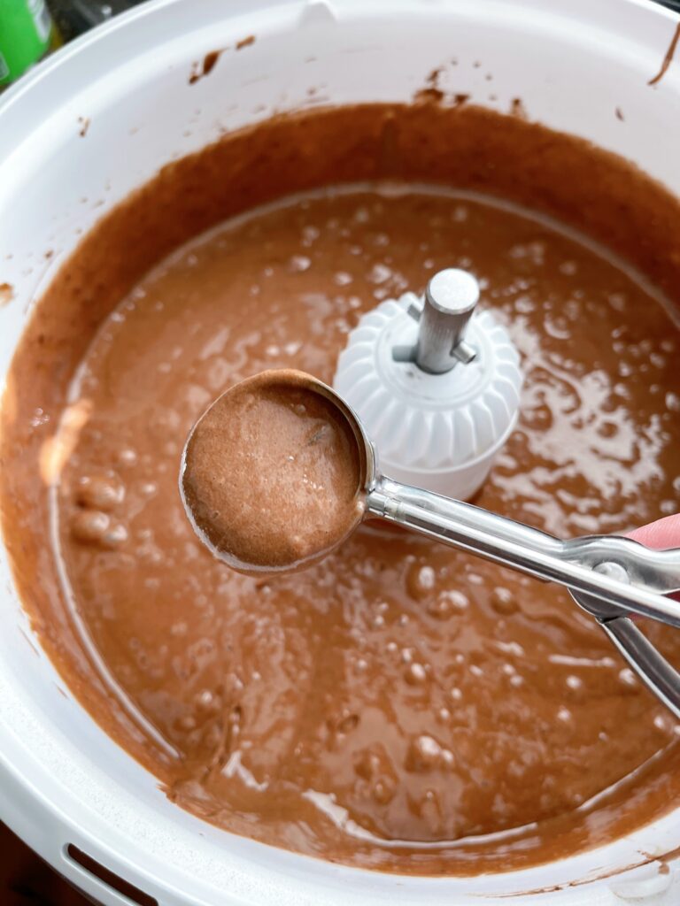 A cookie scoop full of chocolate cake batter.