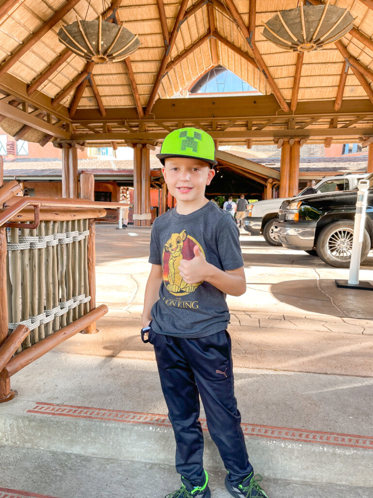 A child at the bus stop fo Disney's Magical Express at Animal Kingdom Lodge.