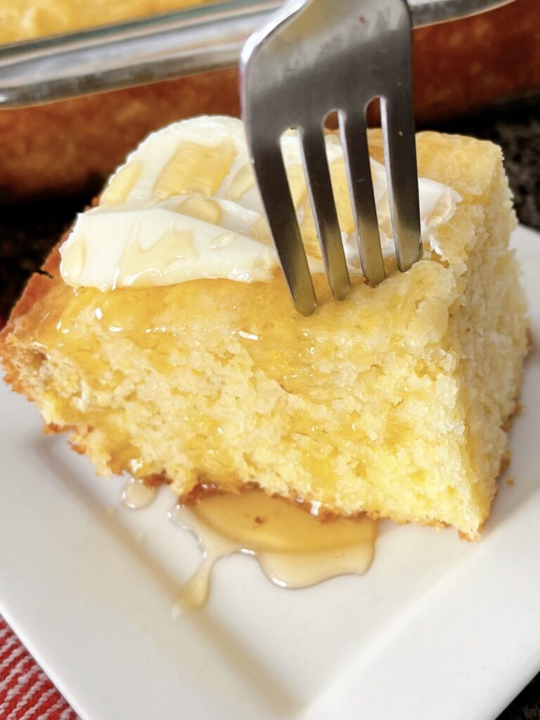 A fork in a piece of cornbread.