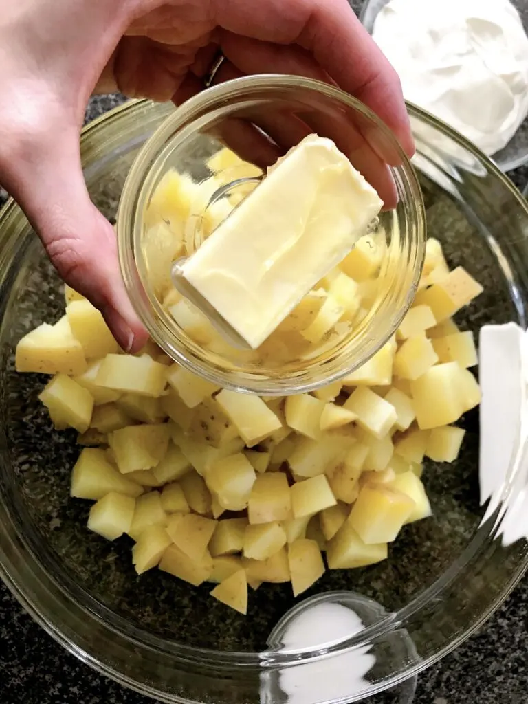 A stick of butter and a bowl of boiled potatoes.