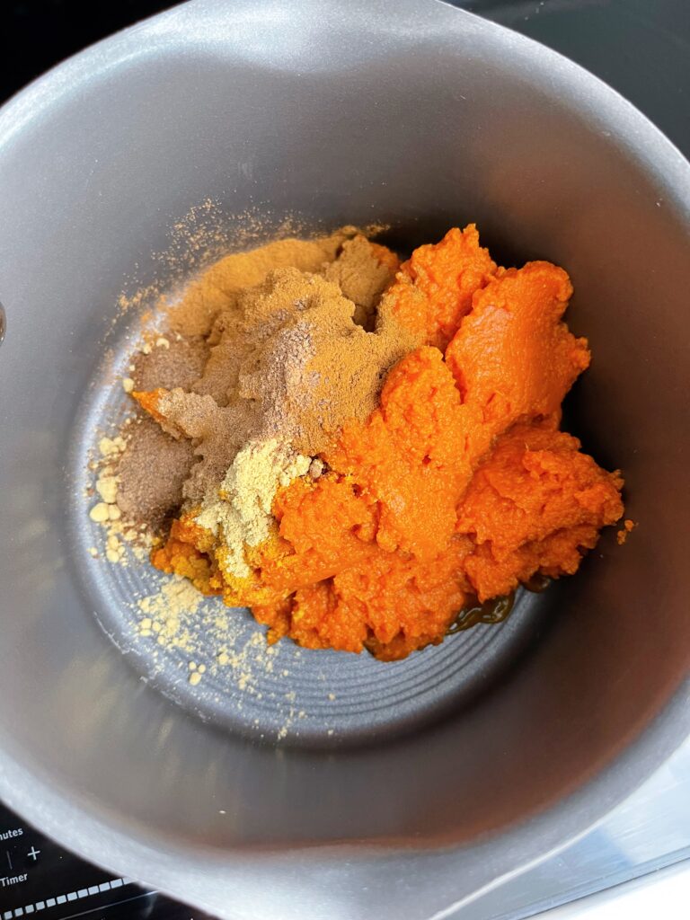 Pumpkin puree and pumpkin pie spices in a sauce pan.