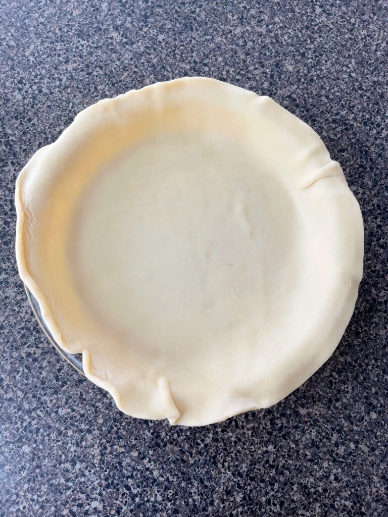 An unbaked pie crust in a pie pan.