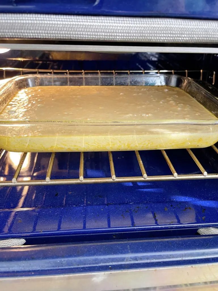 A pan of cornbread batter in the oven.