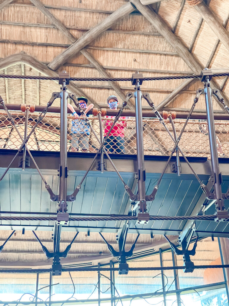 Two kids on a bridge over the lobby of Disney's Animal Kingdom Lodge.