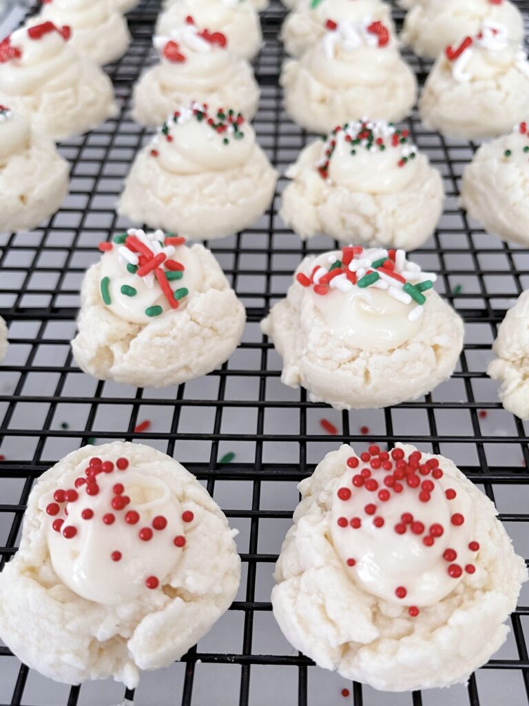 Melt away cookies with white cream cheese icing and topped with Christmas sprinkles.