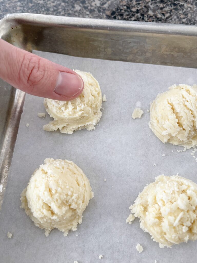 A thump making an imprint on a ball of Melt Away Cookie dough.