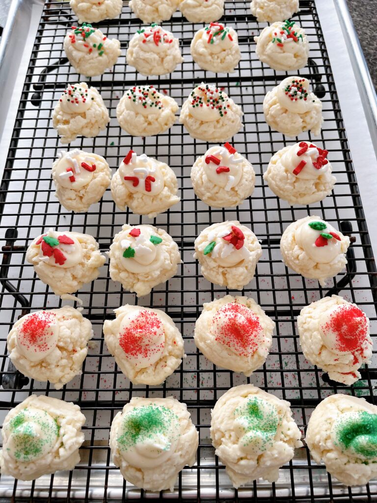 Frosted melt away cookies on a black cooling rack.