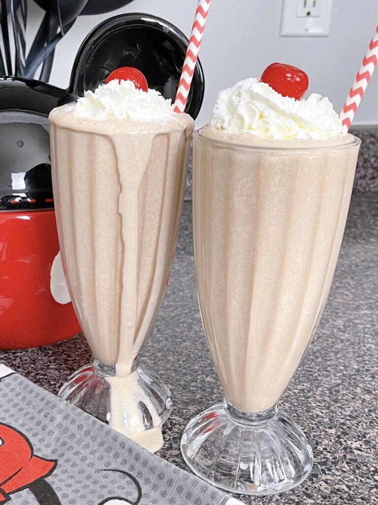 Two chocolate malts with whipped cream.