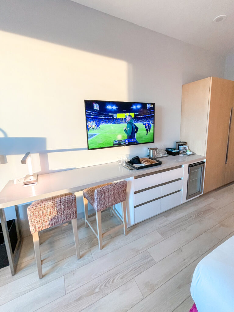 Desk, drawers, mini fridge, and tv in a guest room at Radisson Blu Anaheim.