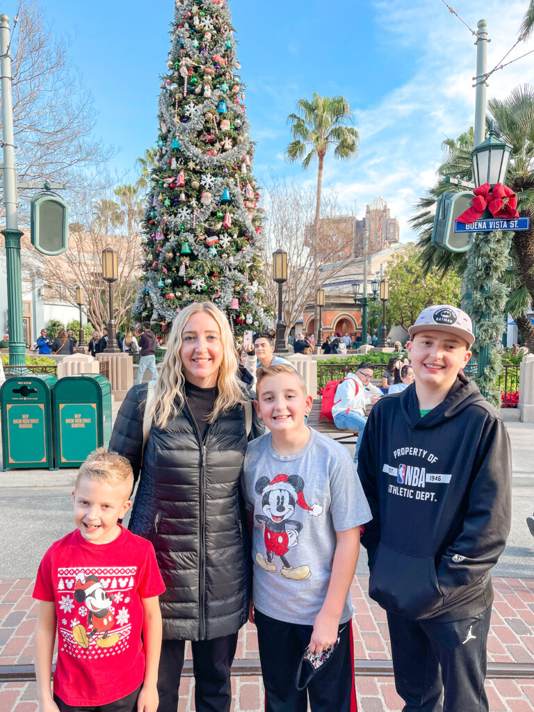 A family in front of the Christmas tree at Disney California Adventure.