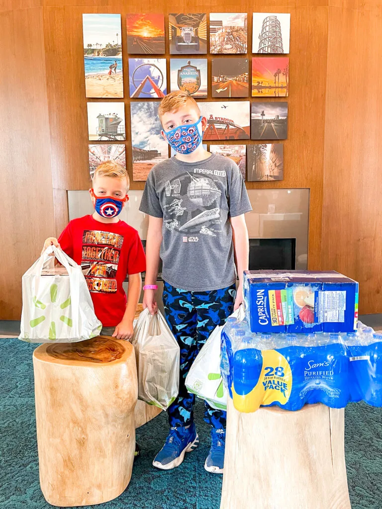 Two kids holding groceries delivered to a Disneyland hotel.