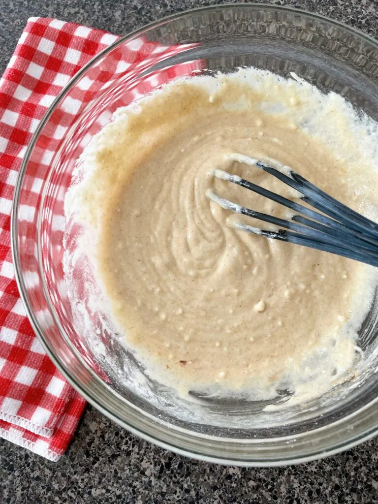 Waffle batter made with pancake batter in a bowl with a whisk.