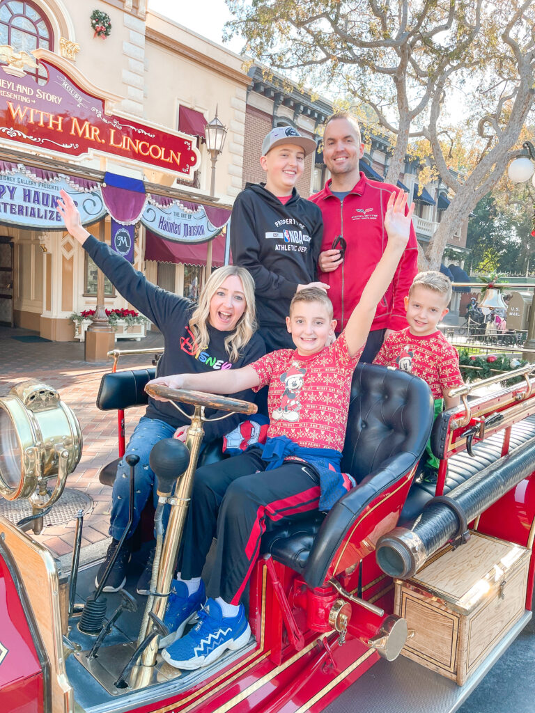 A family in the Disneyland fire engine in front of Great Moments with Mr. Lincoln.