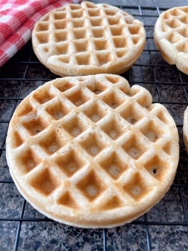 A closeup view of a waffle on a cooling rack.