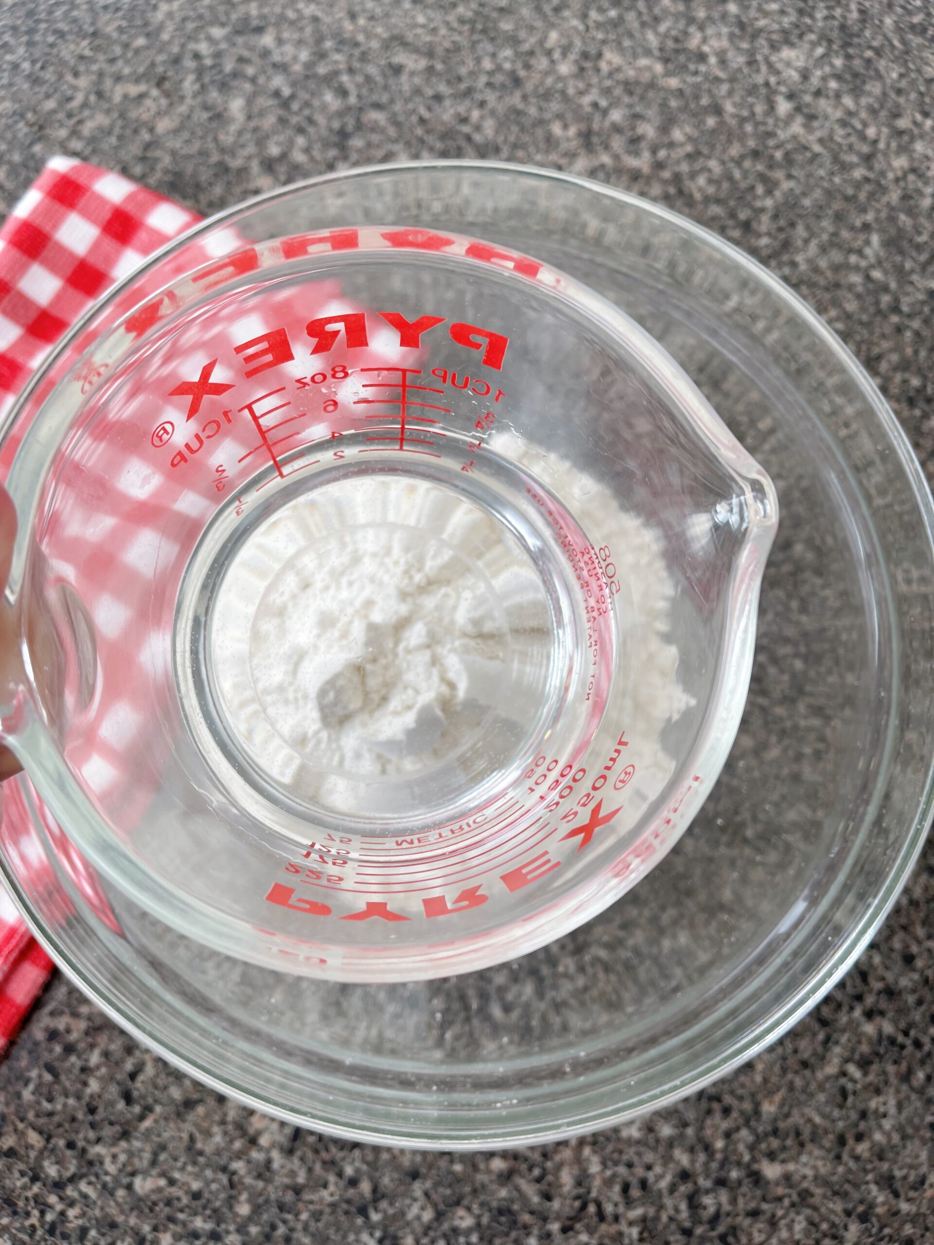 A measuring cup of water and a bowl of pancake mix.