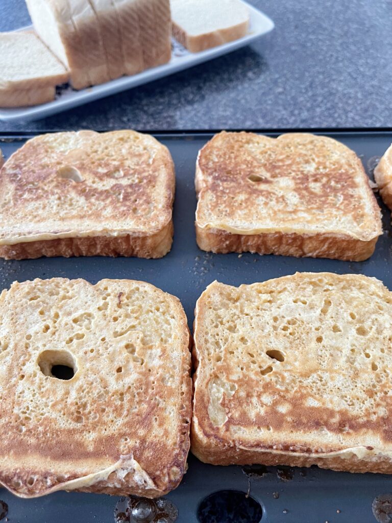 French Toast cooking on a griddle.