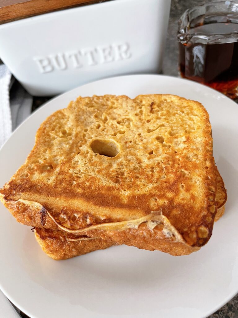 Two slices of French Toast with butter and syrup.