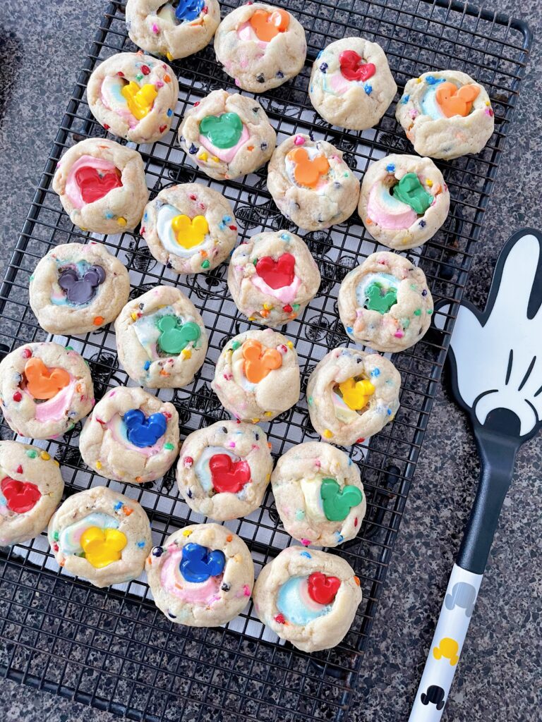 Marshmallow Rainbow chip cookies with colorful mickey mouse chocolate chips on a cooling rack.