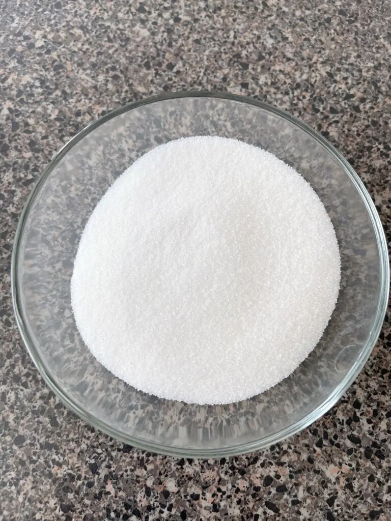 A clear bowl of sugar.