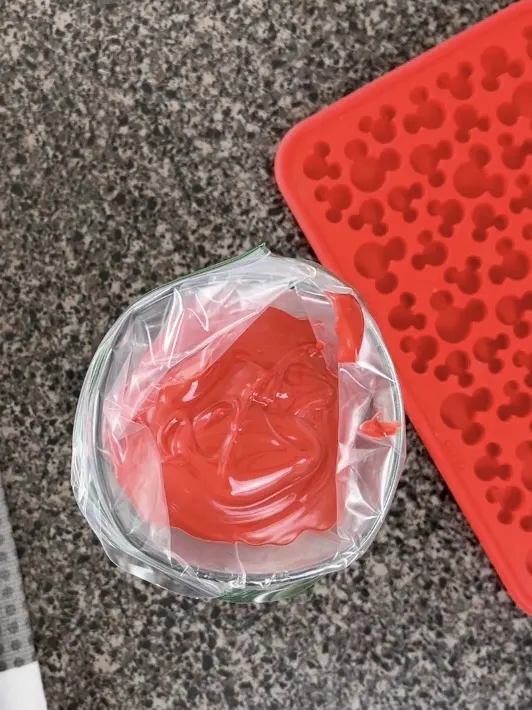 Melted red candy melts in a ziplock bag.