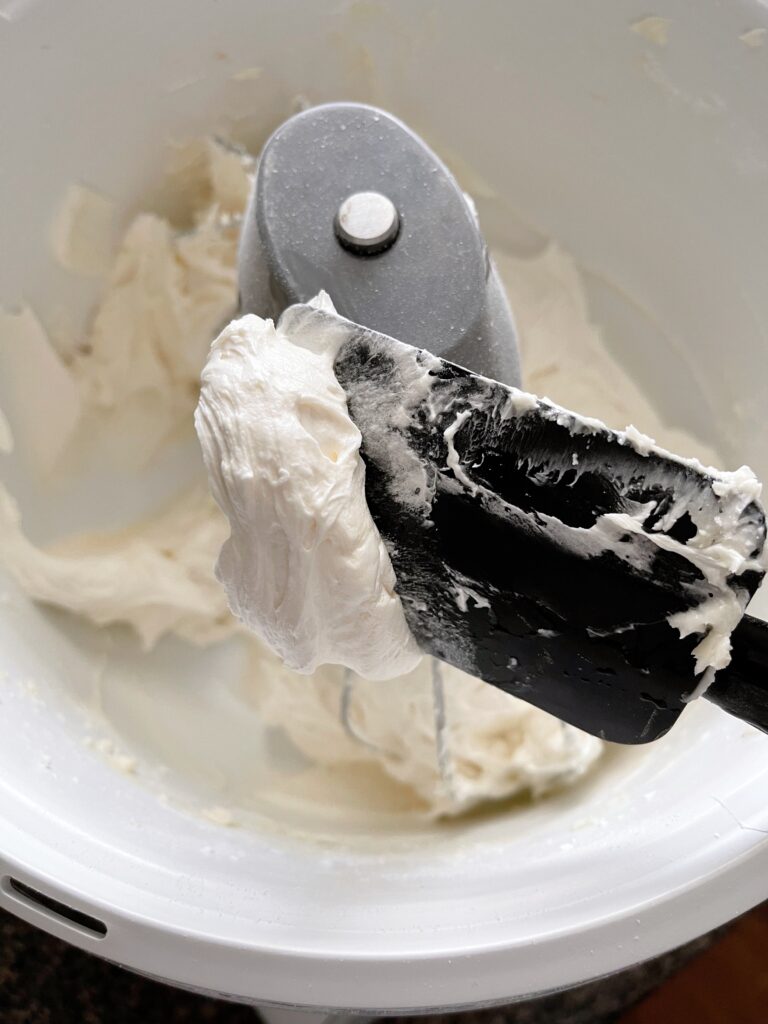 Classic vanilla buttercream frosting on a black spatula.