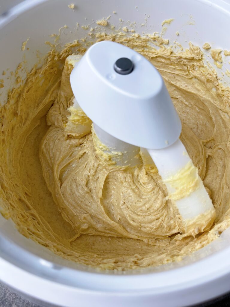 Butter, sugar, and brown sugar mixed together in a mixing bowl.