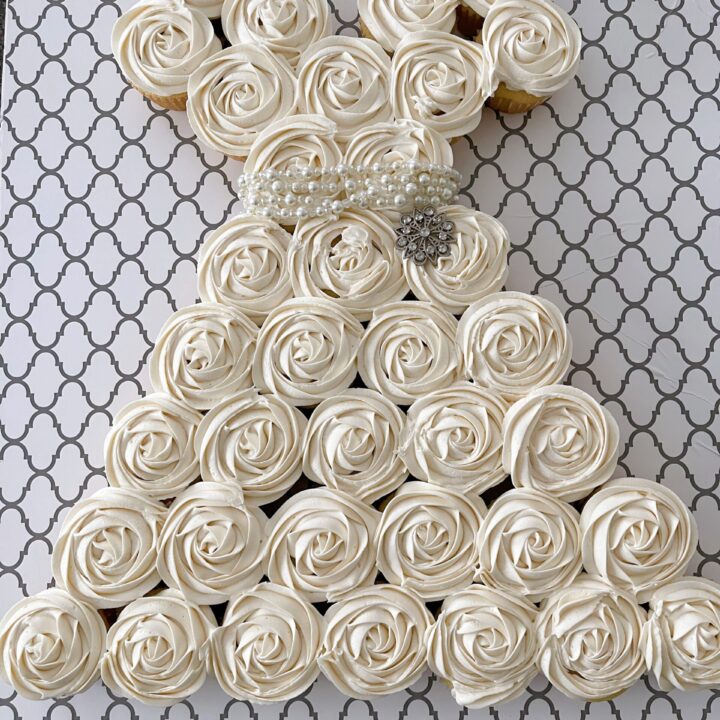 A pull apart cupcake cake shaped like a white dress.