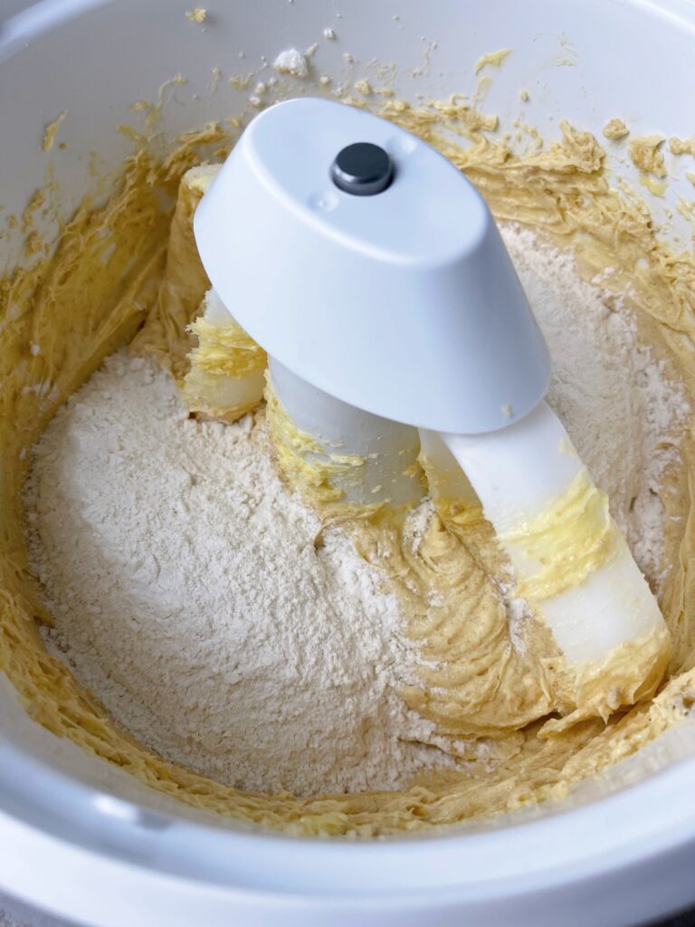 Cookie dough dry ingredients in a bowl with mixed butter and sugar.